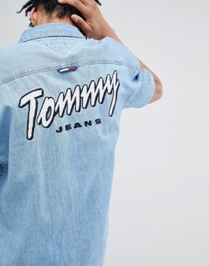 Джинсовая оверсайз-рубашка с короткими рукавами и вышитым логотипом To Tommy Jeans. Цвет: синий